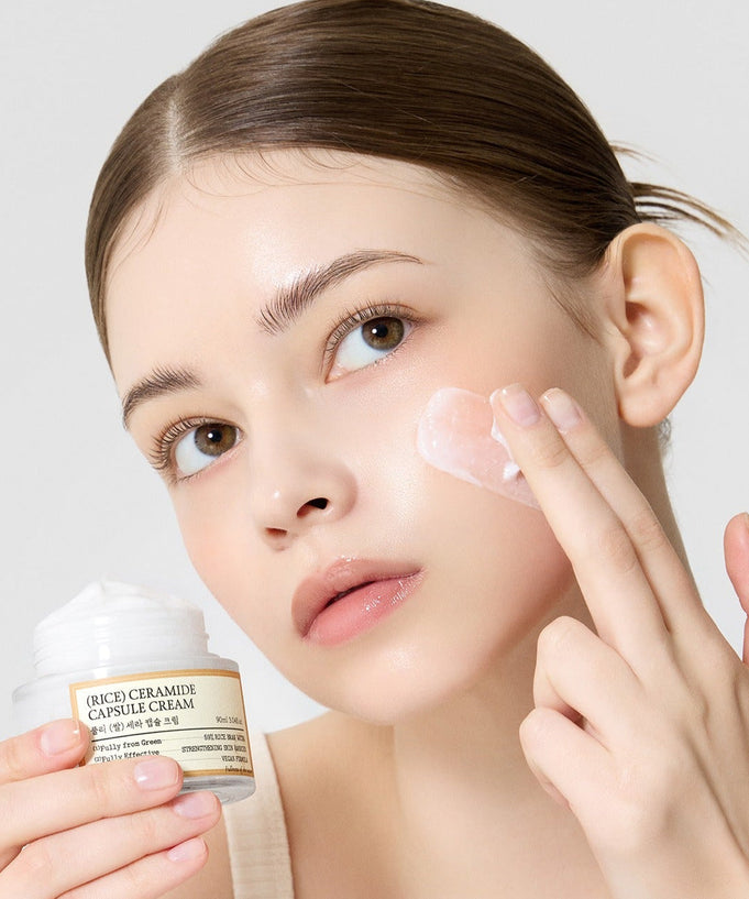 Woman applying FULLY Rice Sera Capsule Cream 90ml skincare product to her face for moisture and care.