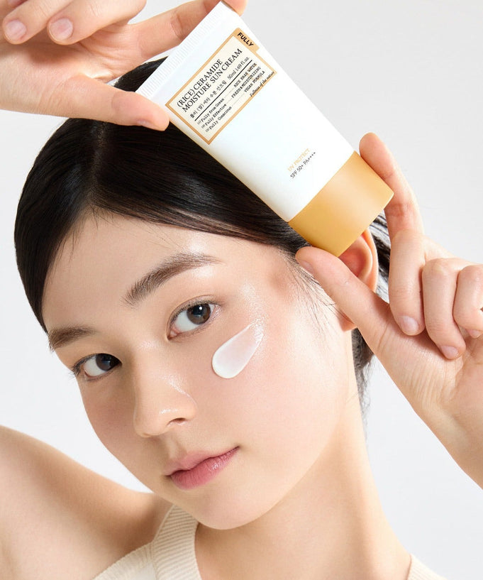 Woman applying FULLY Rice Sera Moisture Sunscreen 50ml to her face