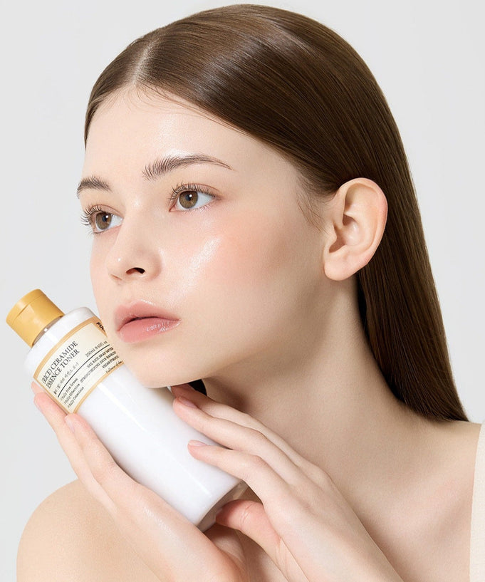 Model holding a bottle of FULLY Rice Serum Essence Toner 250ml with glowing skin.