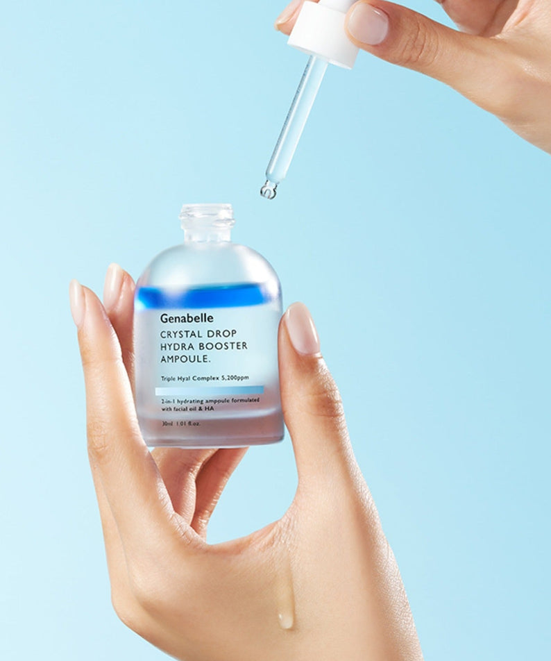GENABELLE Crystal Drop Hydra Booster Ampoule 30ml held by hands with dropper against blue background