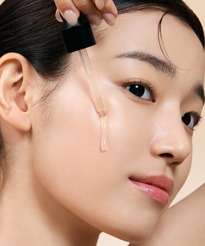 Woman applying MILK TOUCH Ginseng Gold PDRN Double Boosting Serum 30ml to her face for radiant skin.