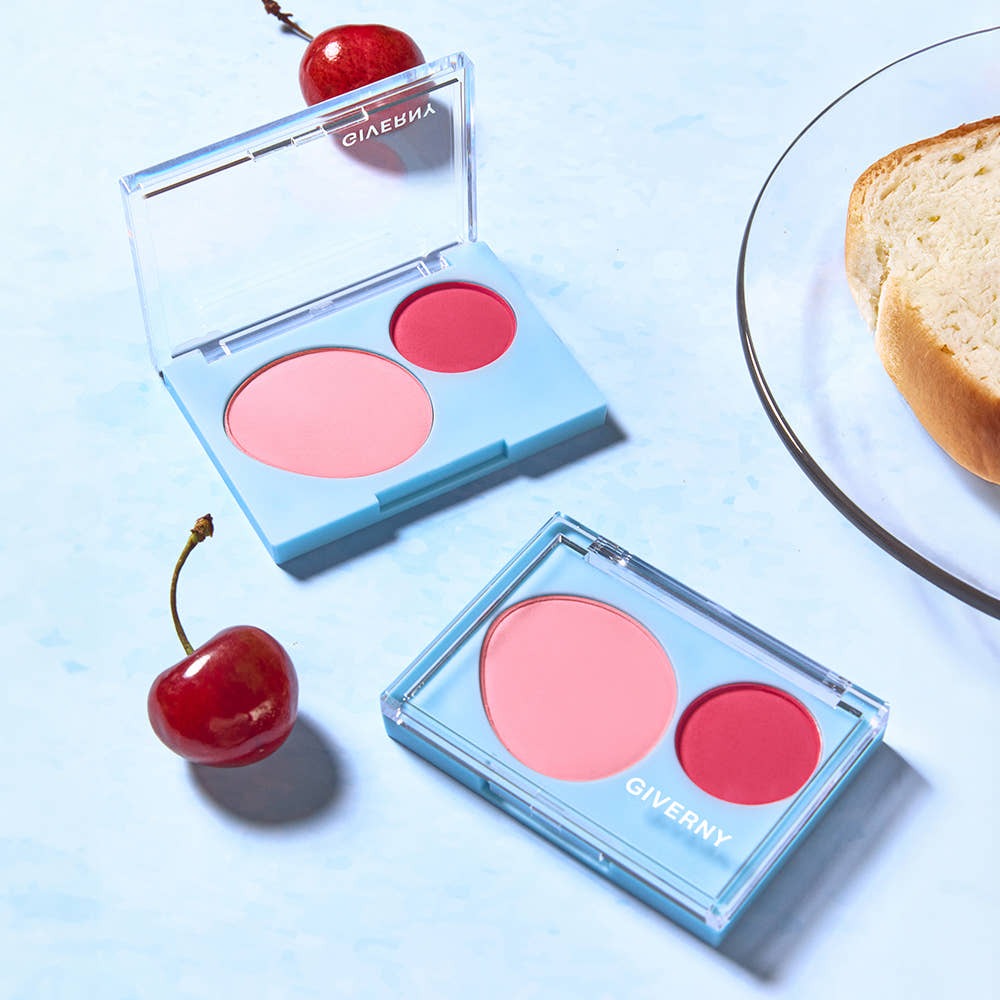 GIVERNY Fluffy Dual Blusher 7.4g with vibrant pink and red tones, open on a light blue background with decorative cherries.