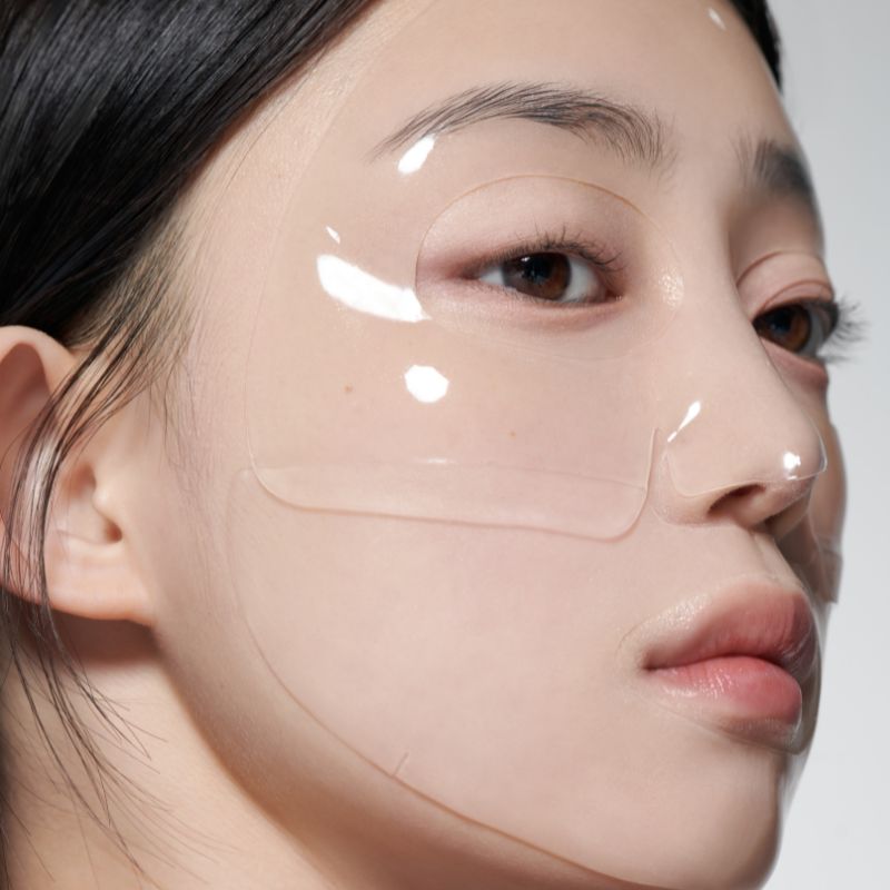 Close-up of a person wearing GLOW Aloe Hydrogel Mask Pack 3ea, highlighting the glossy texture and translucent appearance on skin.