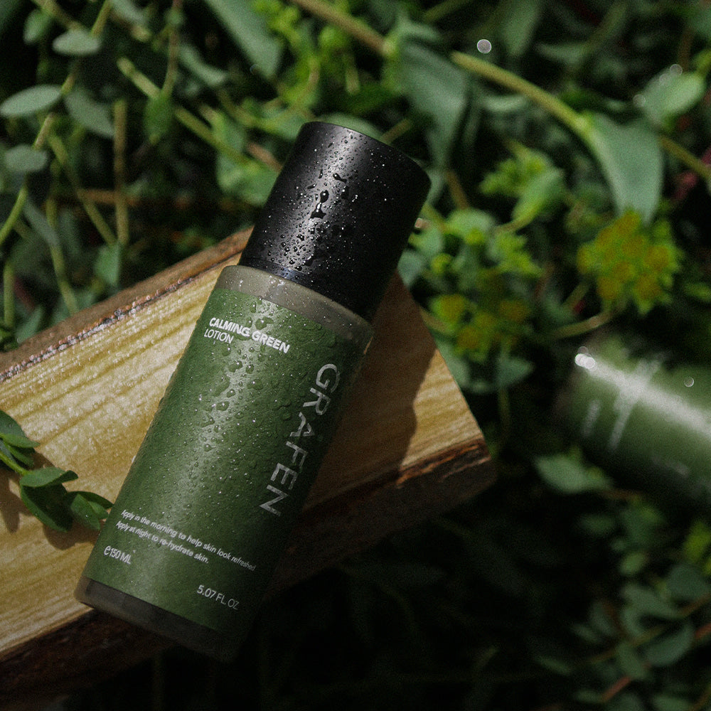 GRAFEN Calming Green Lotion 150ml bottle on wooden plank with dewy leaves, Gentleman Korea men’s skincare product