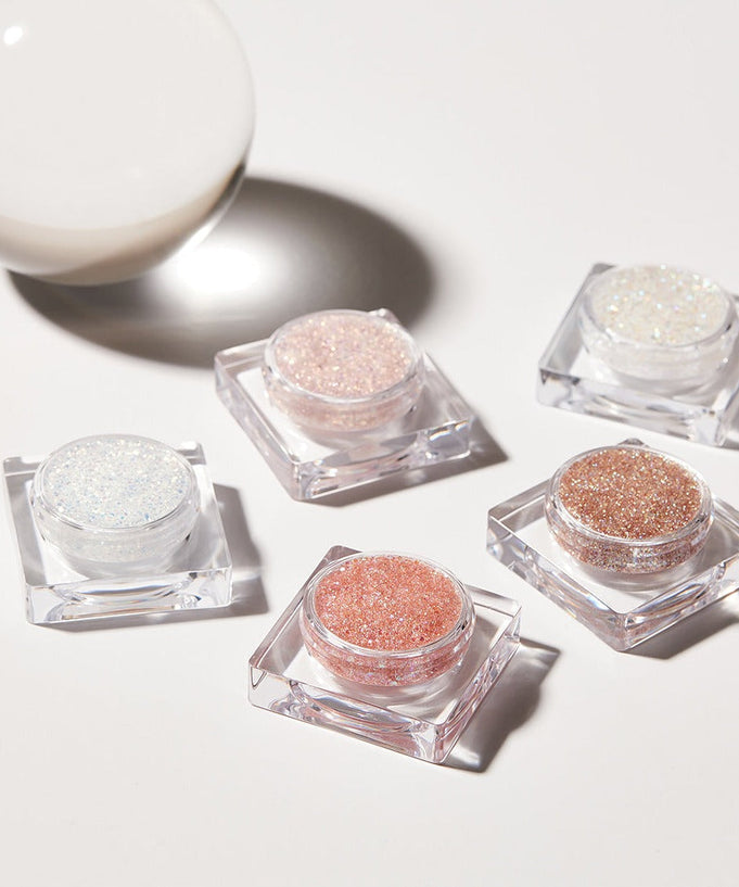 Five containers of GLINT Glitter Gel in various colors with light reflection.