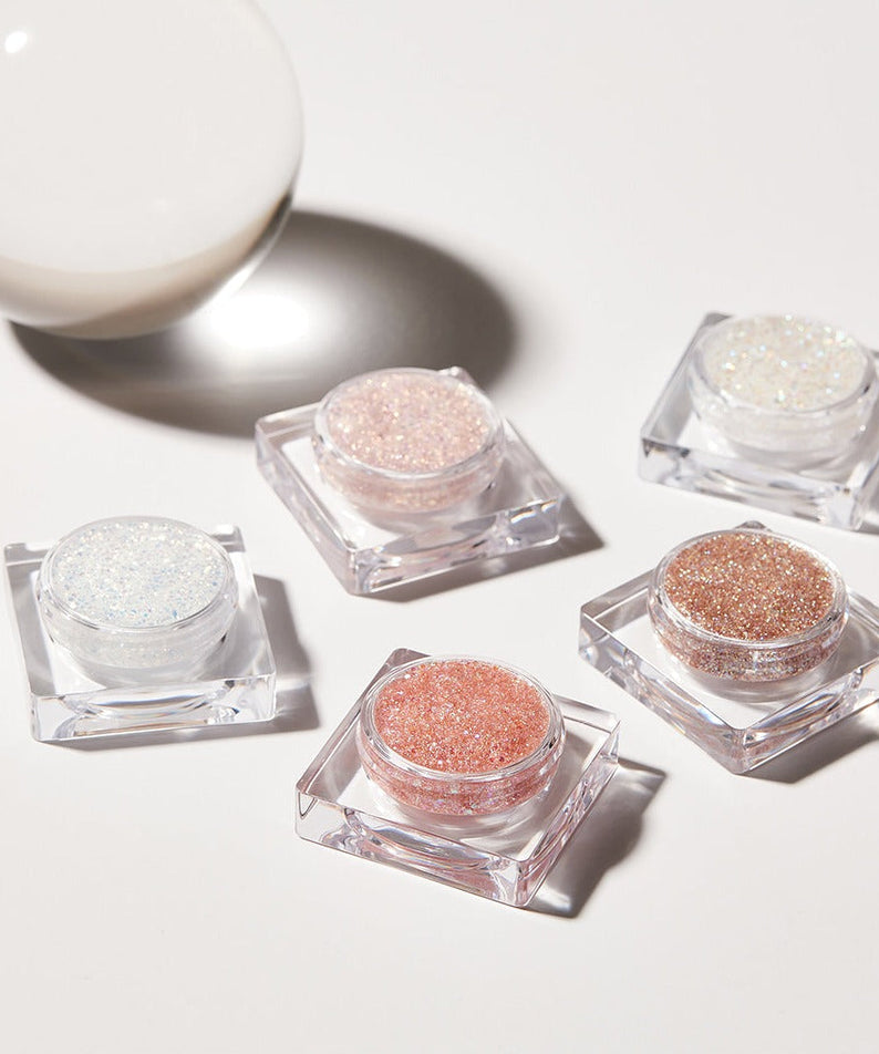 Five containers of GLINT Glitter Gel in various colors with light reflection.