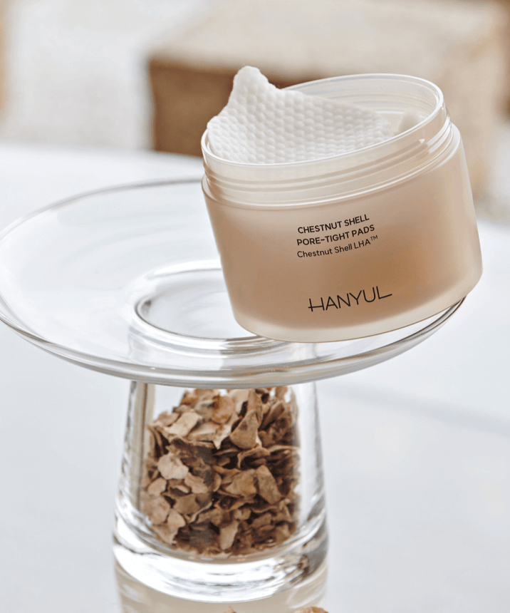 HANYUL Buddleberry Pore Tightening Pad on glass stand next to dried herbs, showcasing pore care and tightening benefits.