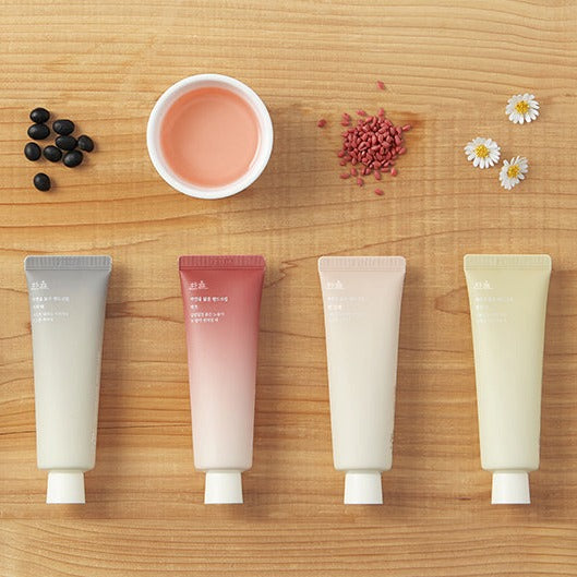 HANYUL Nature in Life Hand Cream 50ml tubes with natural ingredients on wooden background