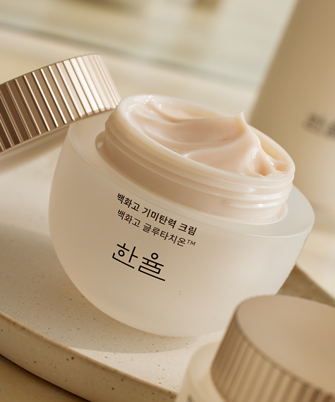 HANYUL Baekhwago Gimitanryuk Eye Cream 25ml in open jar showcasing cream texture on bathroom counter.