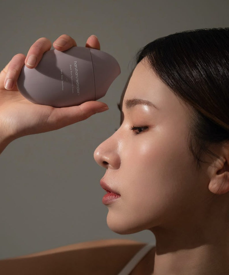 Woman holding HARUHARU Black Rice 10 Hyaluronic Cream 50ml