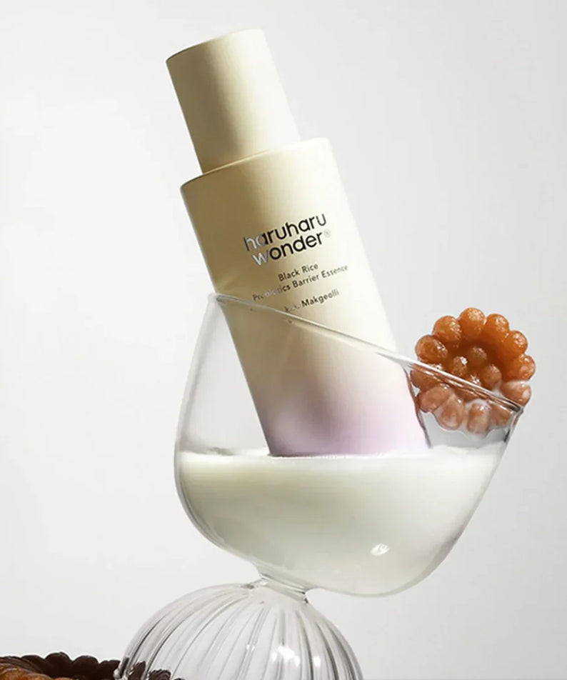 HARUHARU Black Rice Probiotics Barrier Essence 120ml bottle in a glass with white liquid and decorative element.