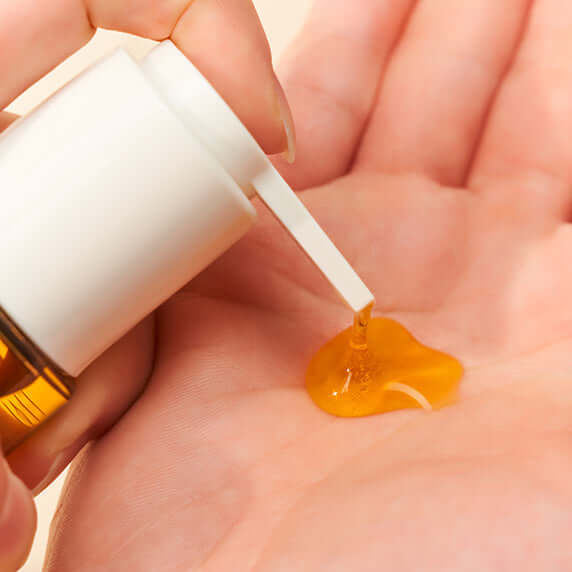 Dispensing HEALING BIRD Revive Repair Hair Oil 70ml into hand, showing texture and consistency.