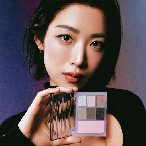 Woman holding HEALUS Color Pairing Palette 10g with various shades of eyeshadow.