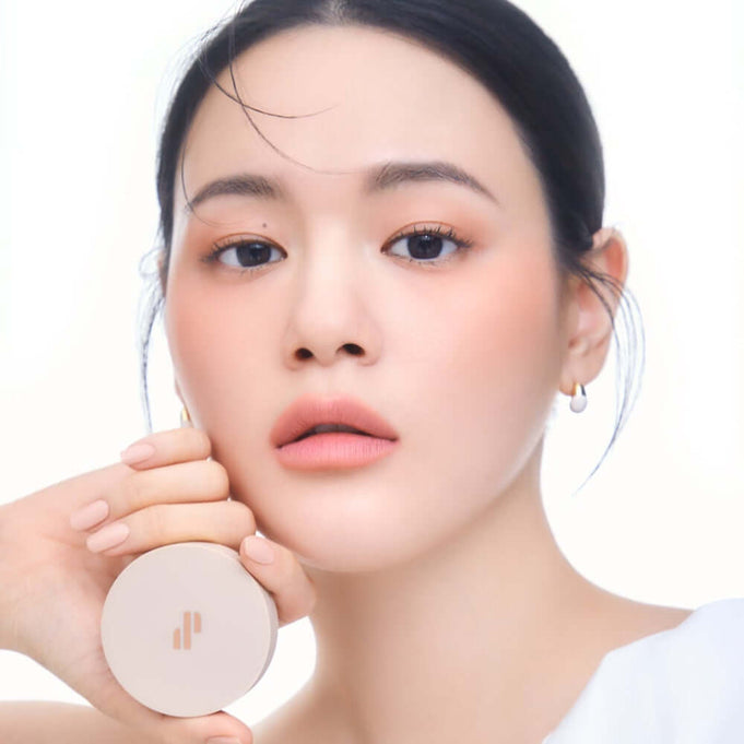 Woman applying HEART PERCENT Dot On Mood Blurry Blush for a soft, natural look.