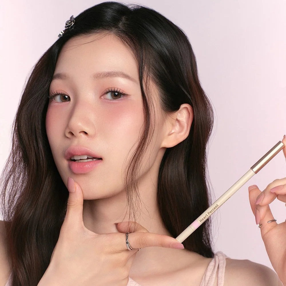 Woman holding HEART PERCENT Dot On Mood Gel Eyeliner Pencil with soft makeup look.