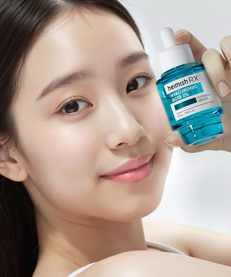Smiling person holding HEIMISH RX Hyaluronic Acid Hydrating Serum 35ml bottle, showcasing hydration skincare product.