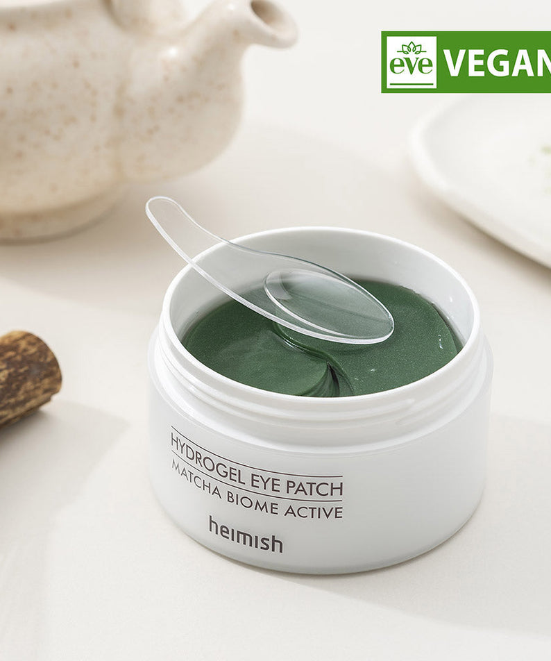 HEIMISH Matcha Biome Hydrogel Eye Patch 60p in open container showcasing green eye patches with applicator, vegan certified