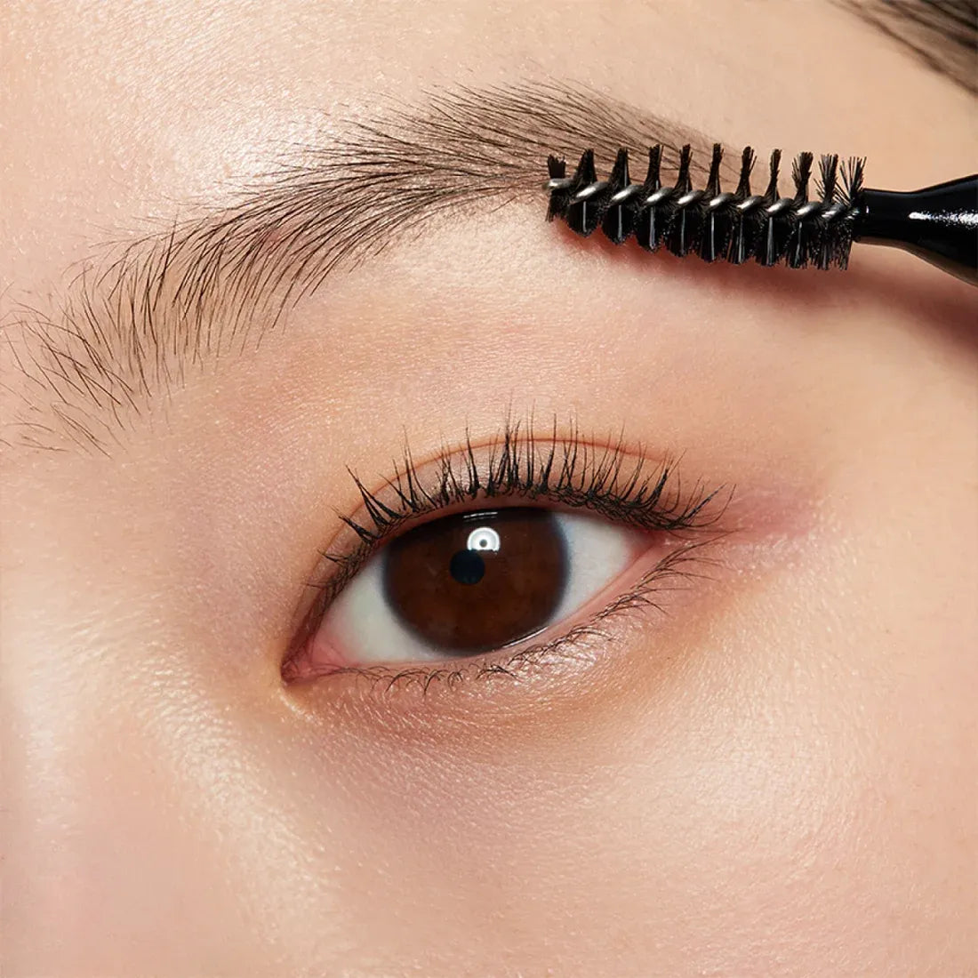Close-up of eyebrow being brushed with HERA Brow Desighner Auto Pencil for perfect brow styling.