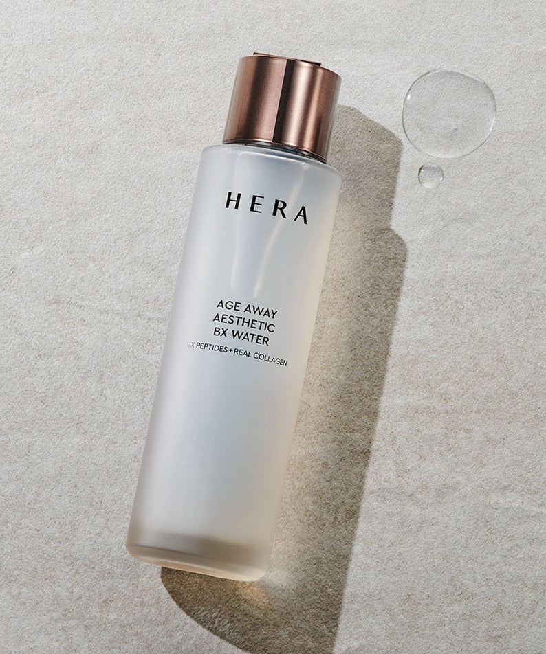 HERA Age Away Aesthetic BX Water 150ml bottle on textured surface with water droplets.