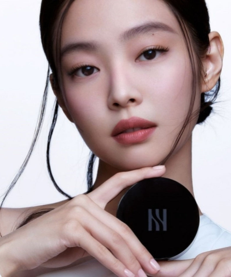 Model holding HERA Black Cushion Foundation SPF34 PA++ 15g showing product packaging.