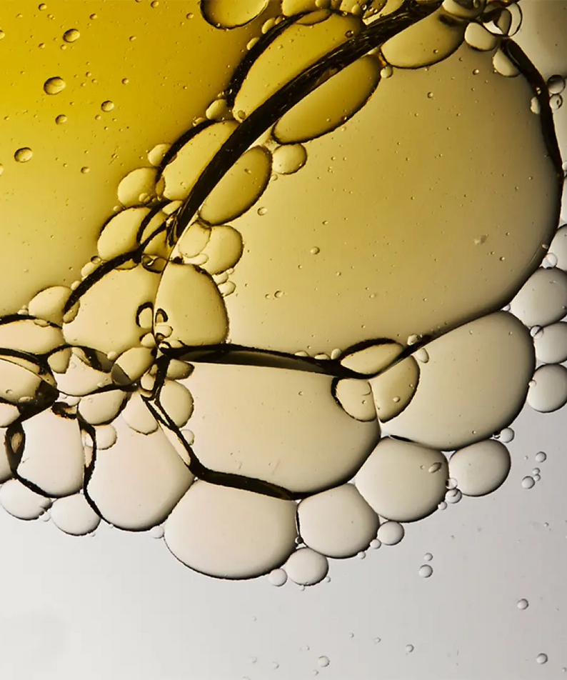 Close-up of oil droplets in water, resembling an abstract pattern, related to HERA Comfy Revitalizing Serum Mist 90ml ingredient texture.