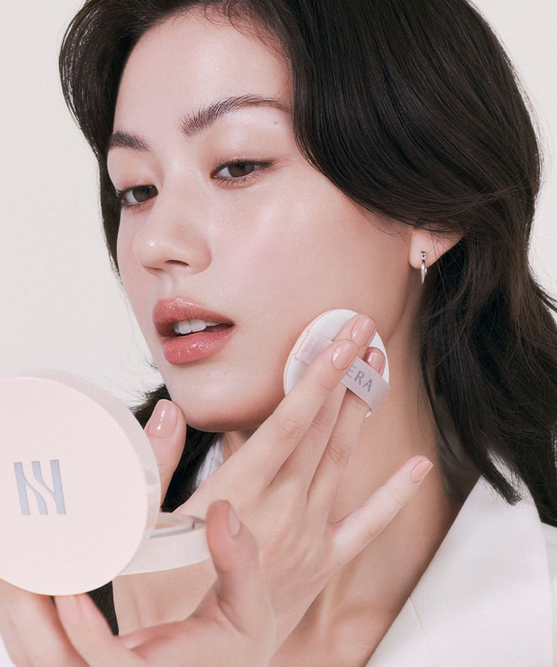 Woman applying HERA Reflection Skin Glow Cushion Foundation 15g for a radiant skin finish.