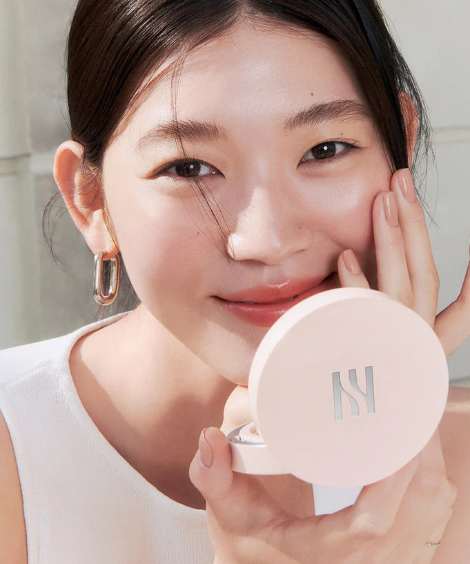 Woman applying HERA Reflection Skin Glow Cushion Foundation 15g for a natural glow