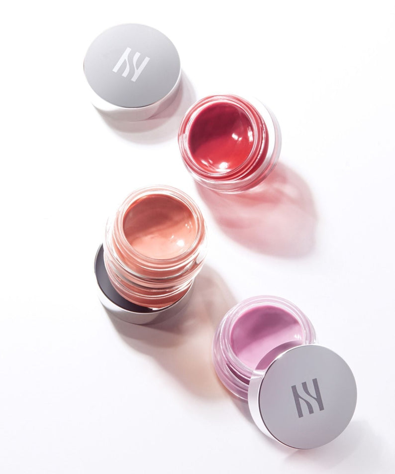 Three open jars of HERA Sensual Lip & Cheek 7g in different shades on a white background.