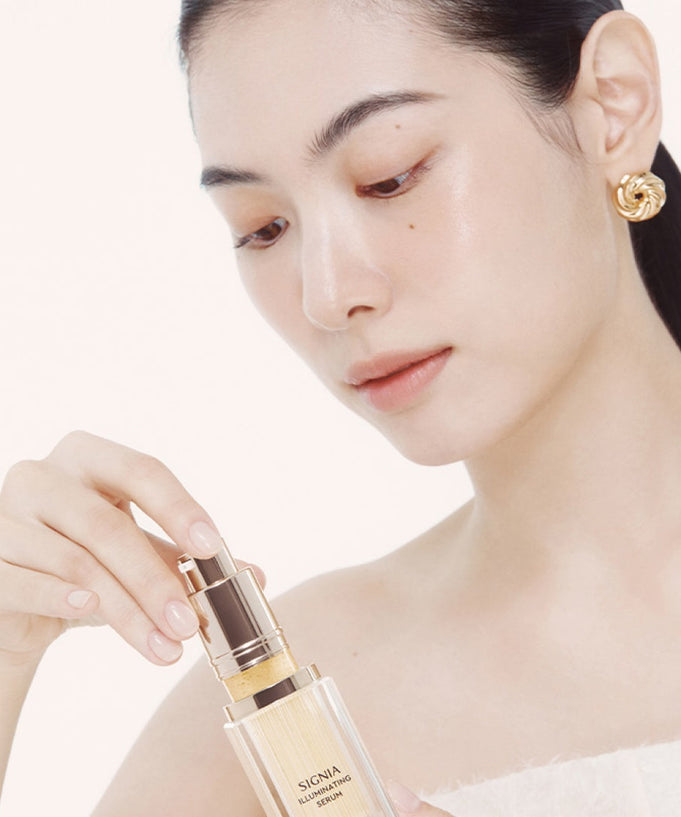 Person applying HERA Signia Illuminating Serum 30ml for radiant skin care