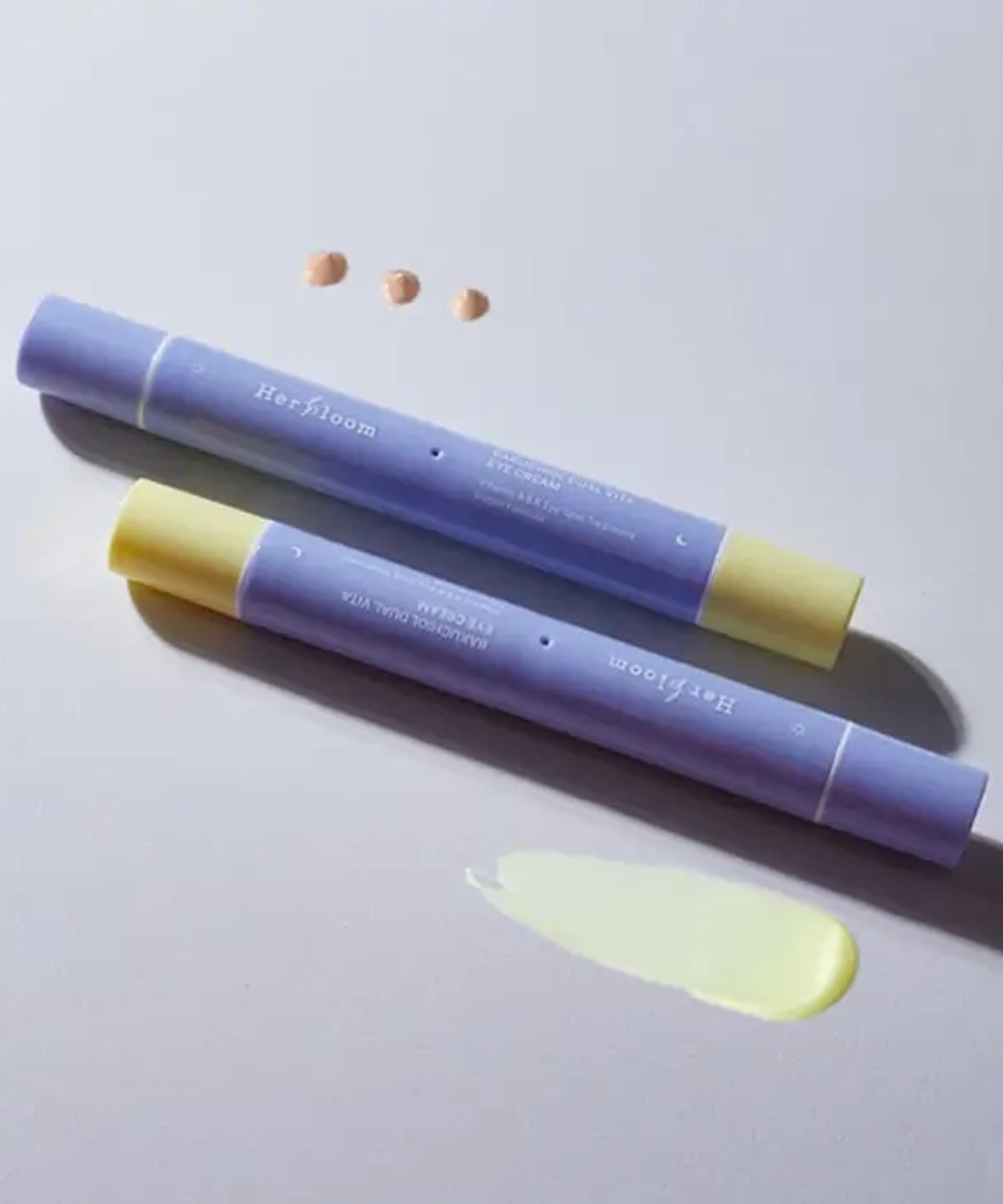 HERBLOOM Bakuchiol Dual Vita Eye Cream tubes with cream swatch on white background