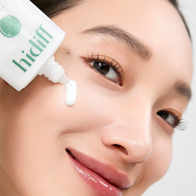 Woman applying HIDIFF Pure Tone Capsule Sunscreen to her face from tube.