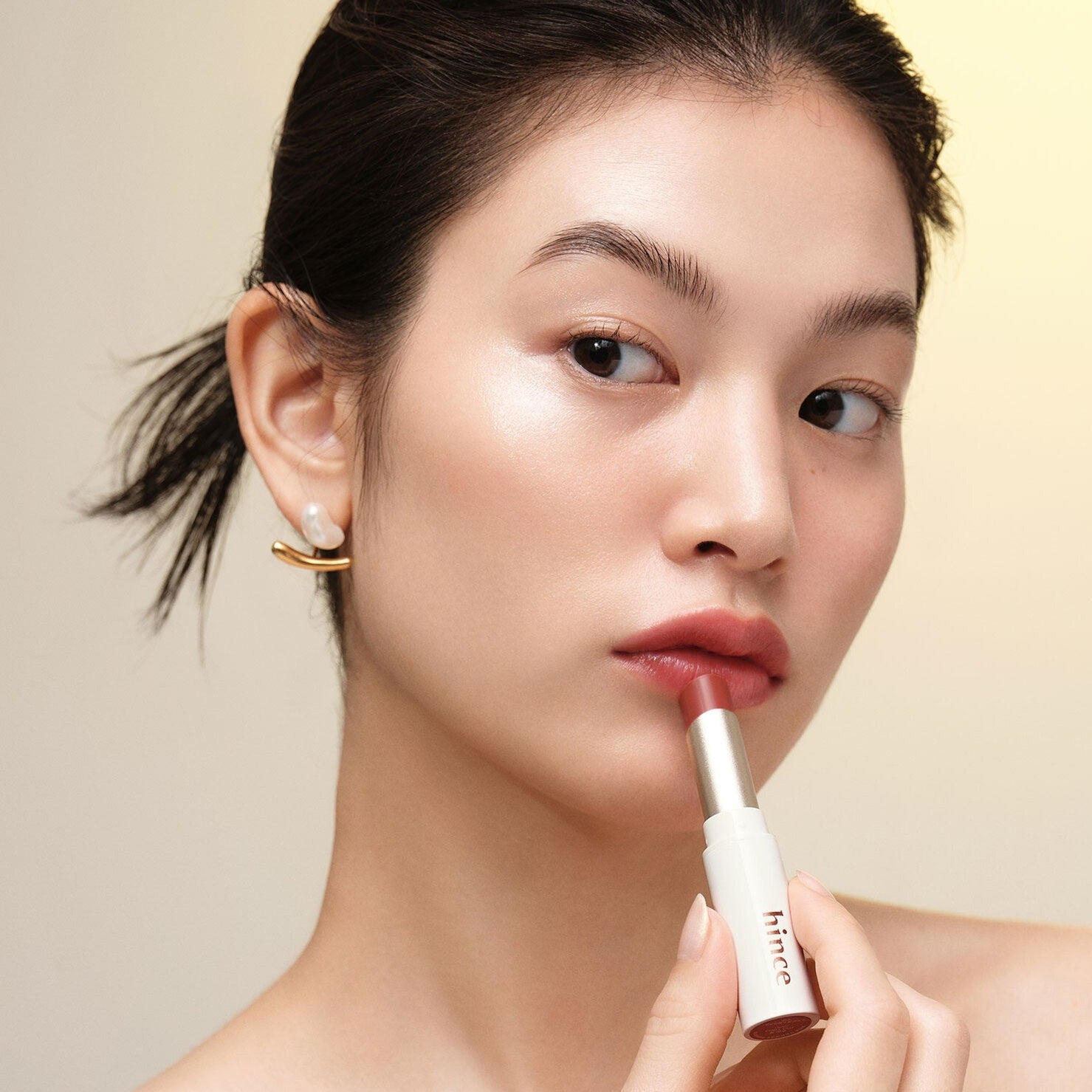 Model applying HINCE Mood Enhancer Lip Glow