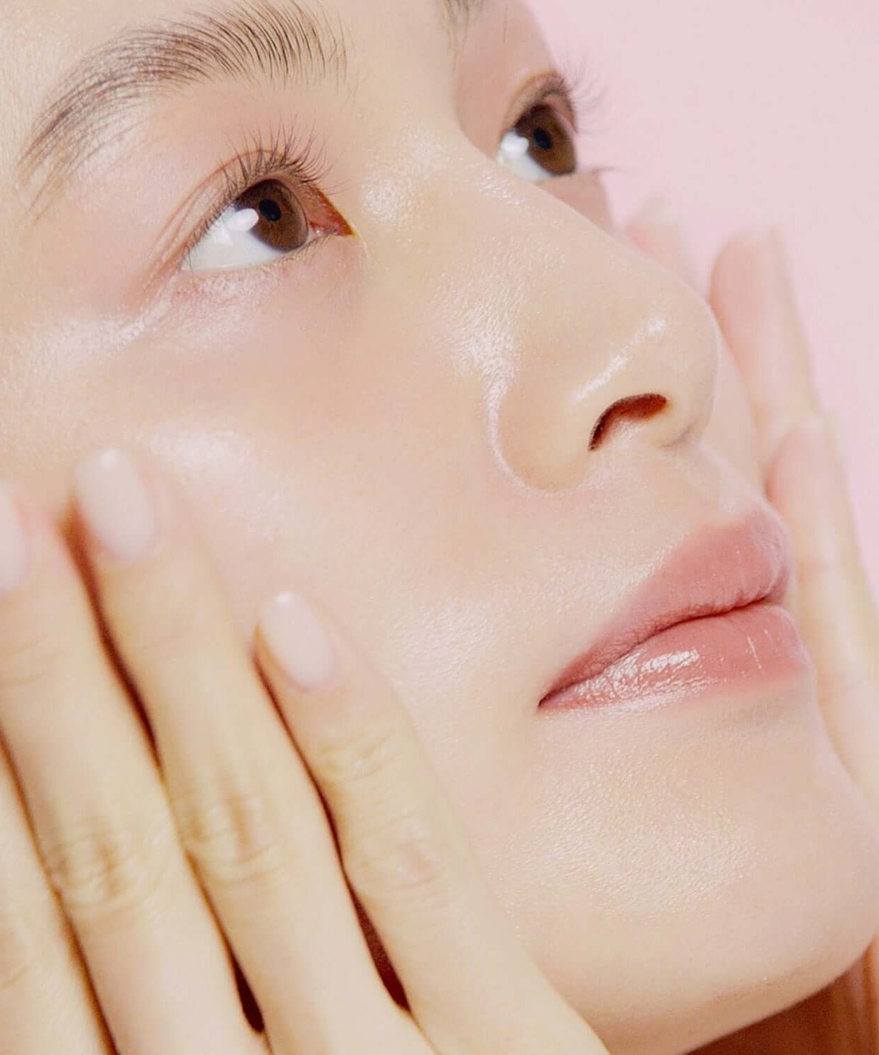 Close-up of woman applying HINCE Second Skin Hydrating Primer, showcasing radiant and hydrated skin.