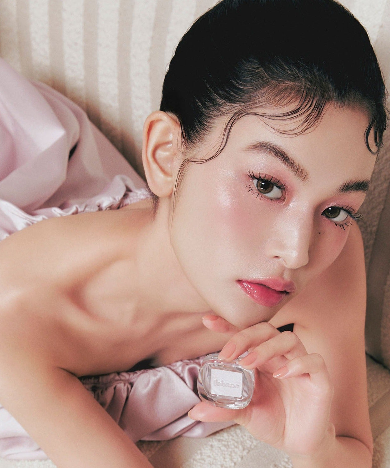 Model holding HINCE Single Eyeshadow, showcasing makeup application