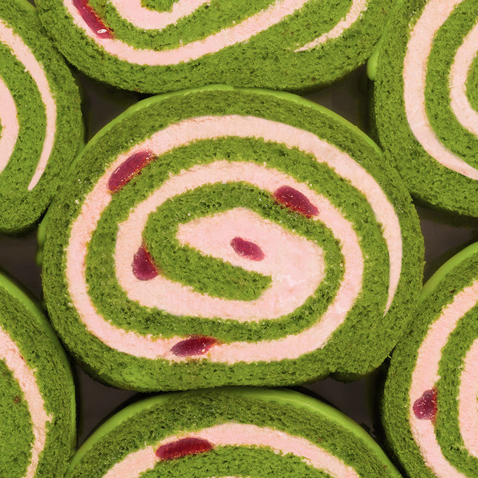 HIT THE TEA Super Matcha Strawberry Rool Cake Gluten-Free green and white swirl cake with strawberry pieces.