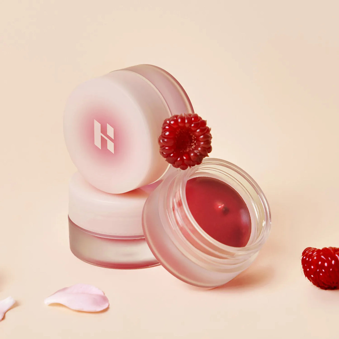 HOLIKA HOLIKA Melting Blur Lip Pot 5g in open container with raspberry decoration on a soft pink background