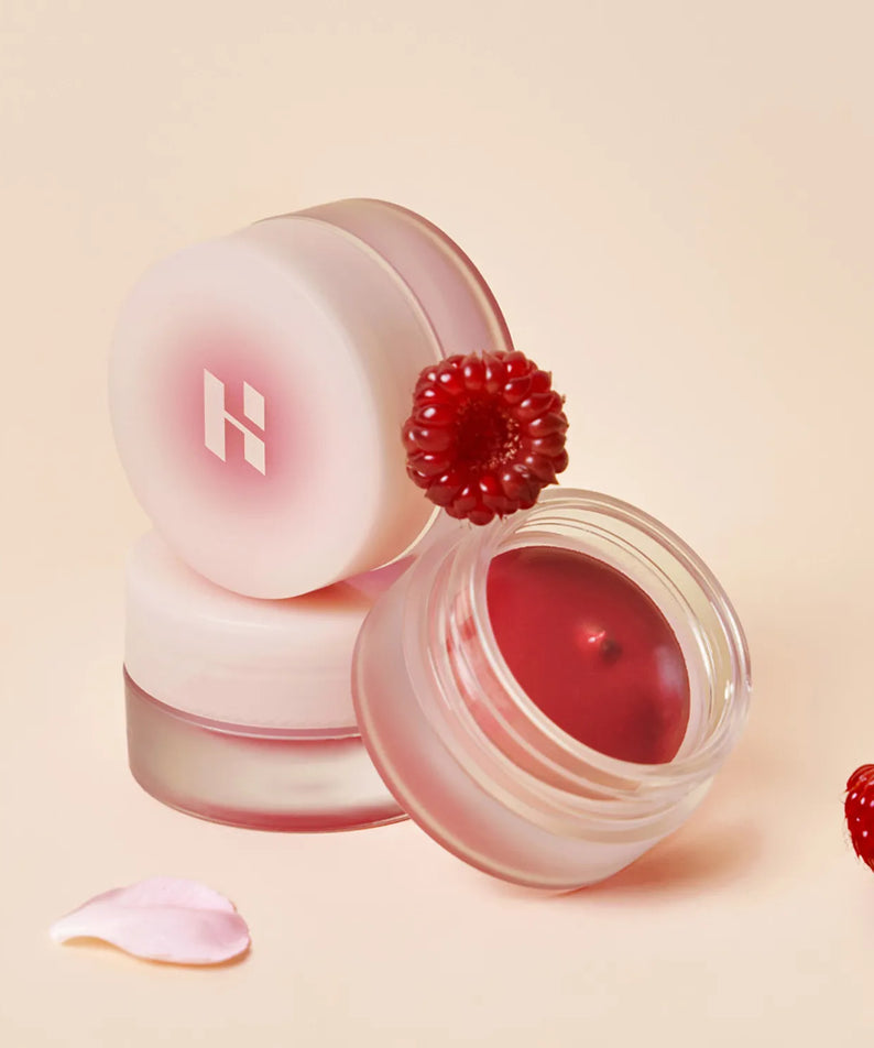 HOLIKA HOLIKA Melting Blur Lip Pot 5g in open container with raspberry decoration on a soft pink background