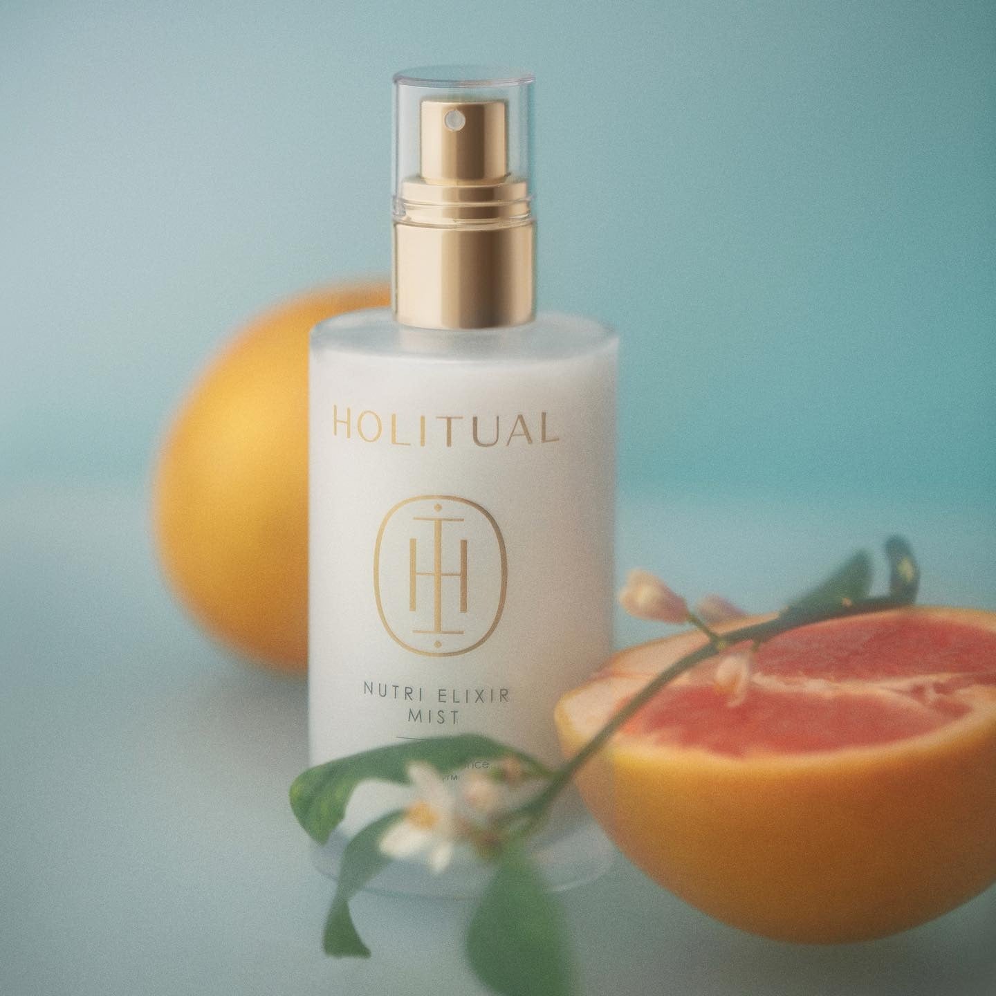 HOLITUAL Elixir Mist 140ml bottle with citrus and floral elements, showcasing the luxury skincare product.