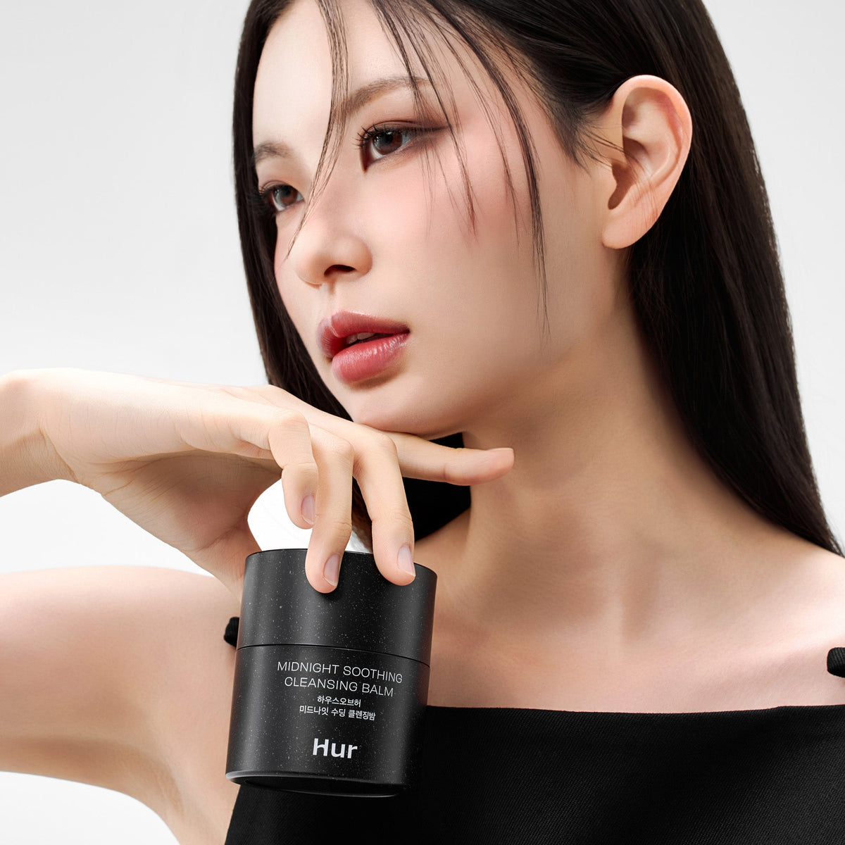 Model holding HOUSE OF HUR Midnight Soothing Cleansing Balm