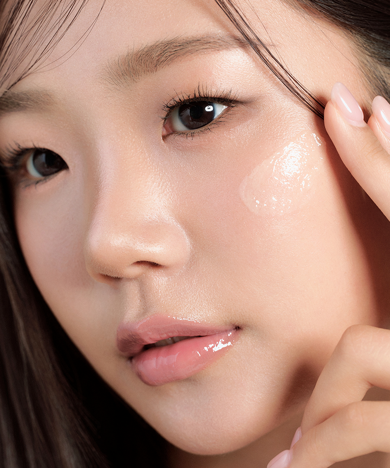 Close-up of a woman applying HOUSE OF HUR 3X Capsule Hydro Booster Cream 50ml on her cheek for hydration and radiance.