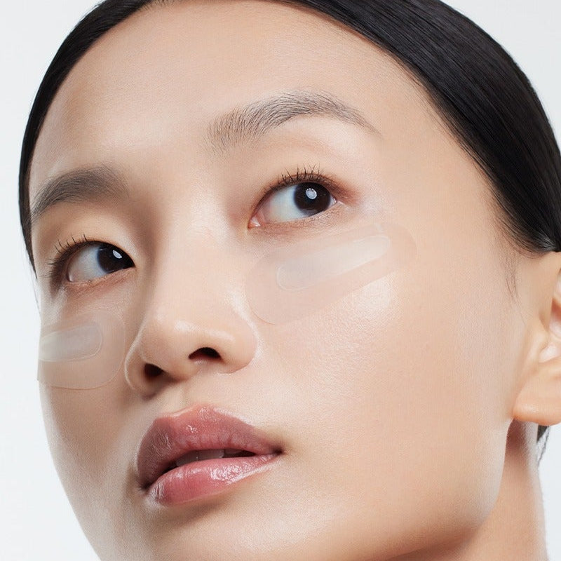 Model wearing HUXLEY BioSIS 360 Micropyramid Patch under eyes