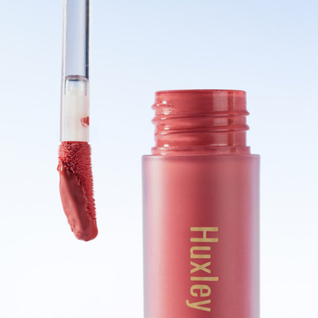 Image of HUXLEY Blurry Tint Hidden Below showcasing product packaging and applicator brush.