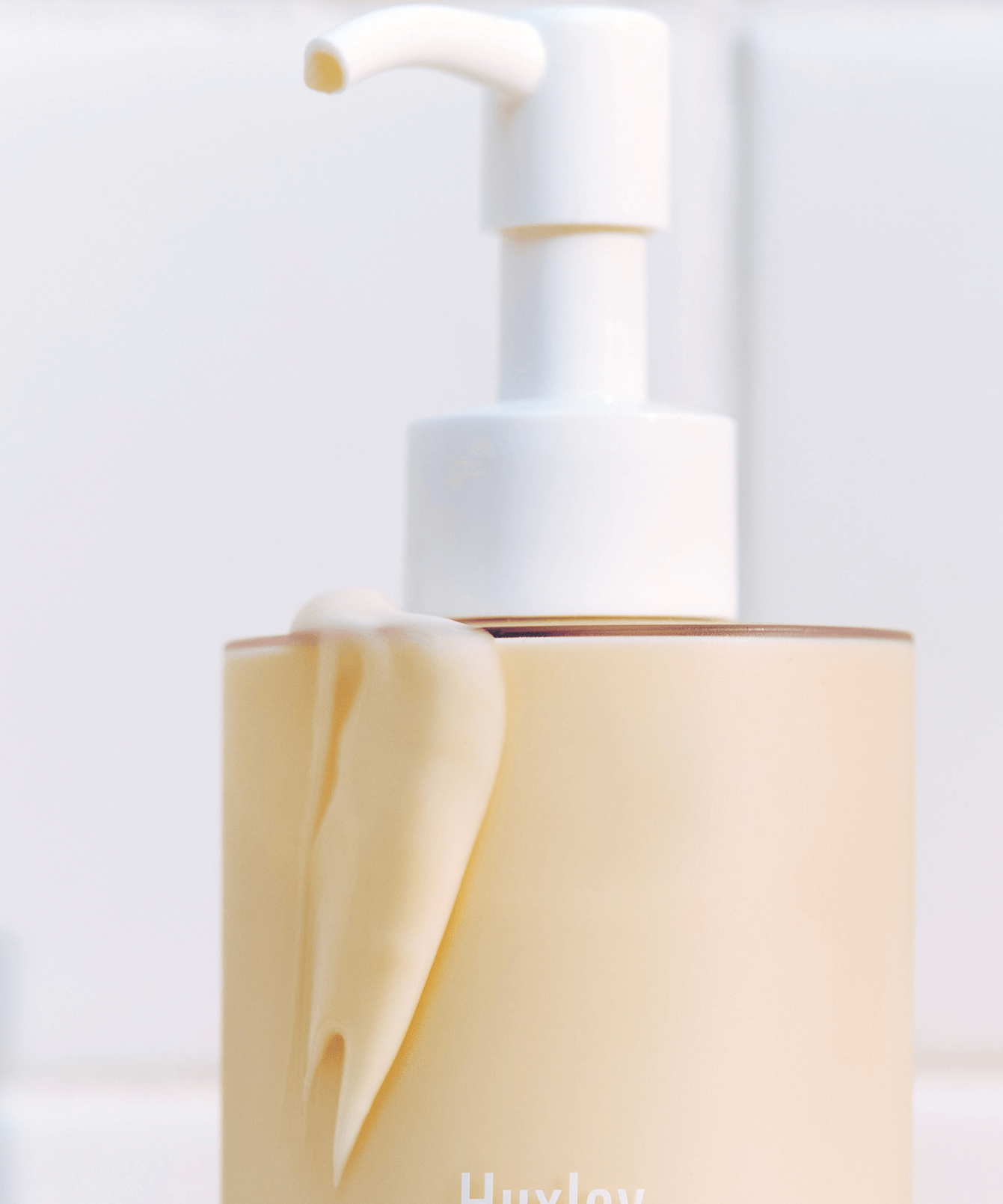 Bottle of HUXLEY Body Lotion Blue Madina Tangerine with pump on a white background.