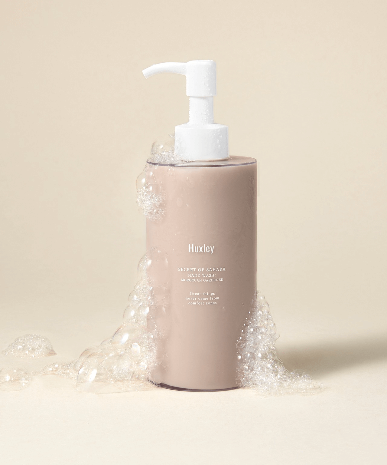 HUXLEY Hand Wash Moroccan Gardener bottle with bubbles on a neutral background.