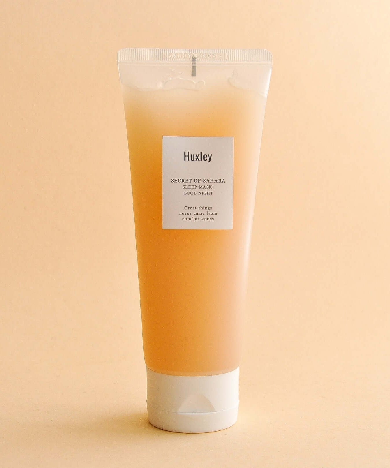 HUXLEY Sleep Mask Good Night tube on a beige background, showcasing the skincare product's packaging and label.