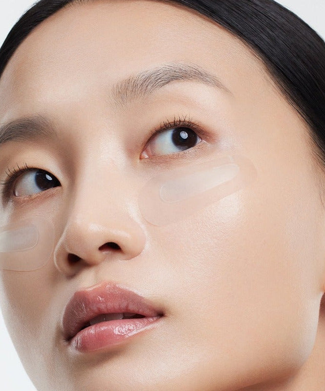 Model wearing HUXLEY BioSIS 360 Micropyramid Patch under eyes