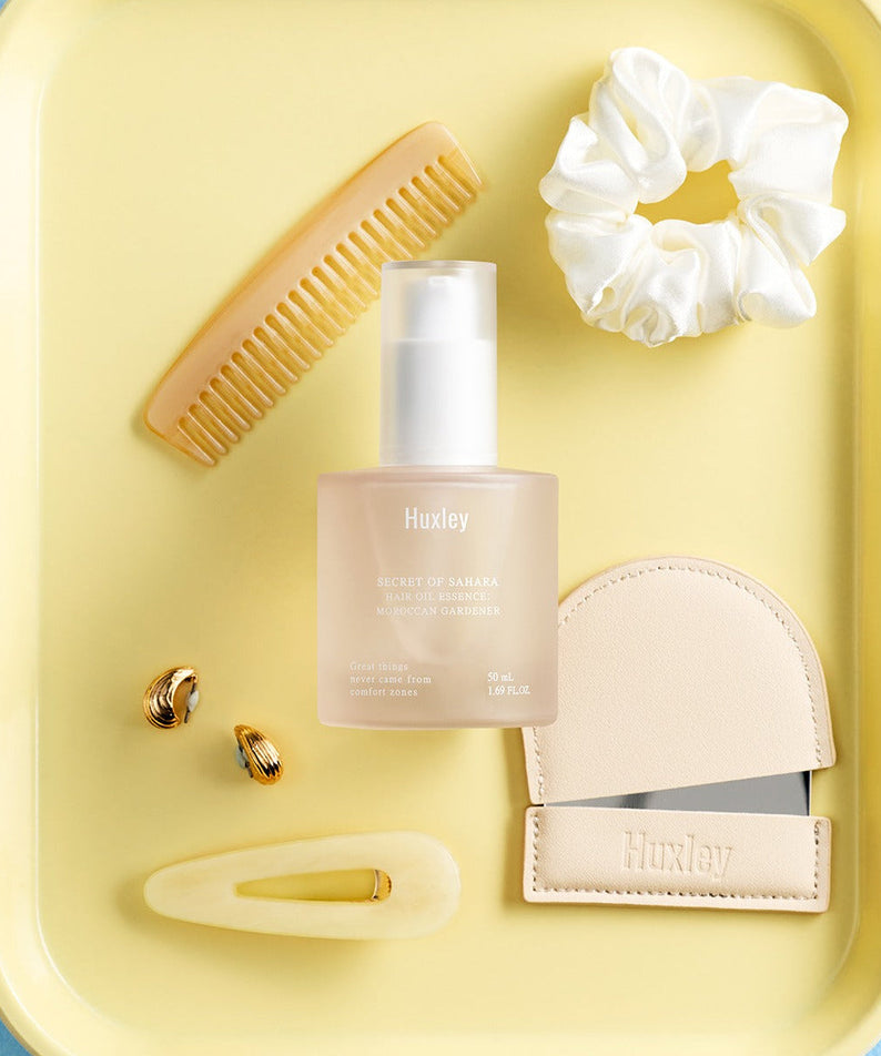 HUXLEY Hair Oil Essence Moroccan Gardener 50ml displayed with hair accessories.
