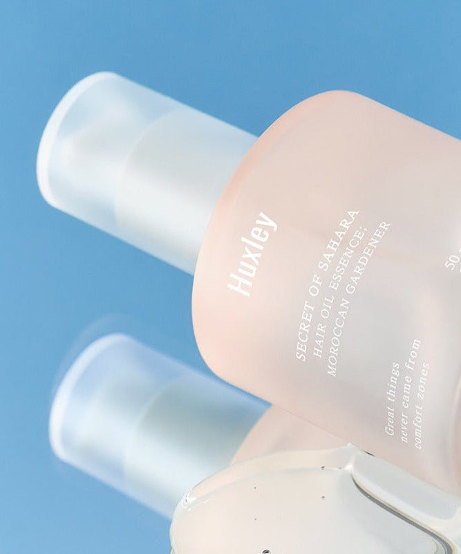 HUXLEY Hair Oil Essence Moroccan Gardener 50ml bottle against a blue background.
