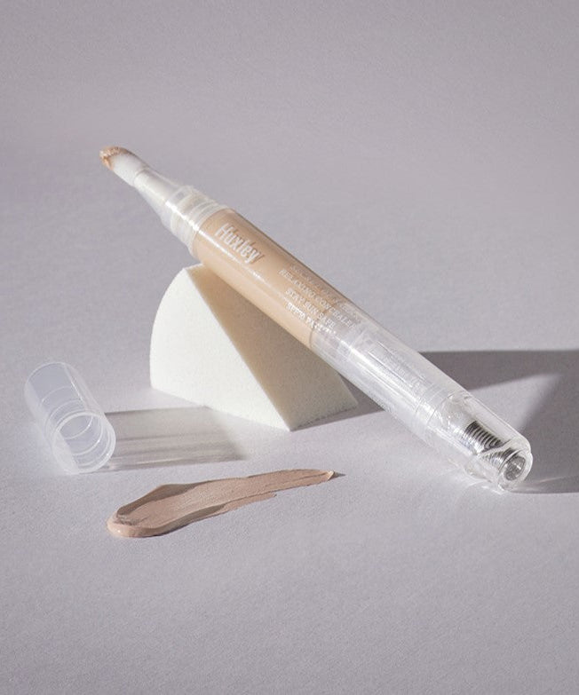 HUXLEY Relaxing Concealer Stay sun Safe displayed with makeup sponge and sample swatch