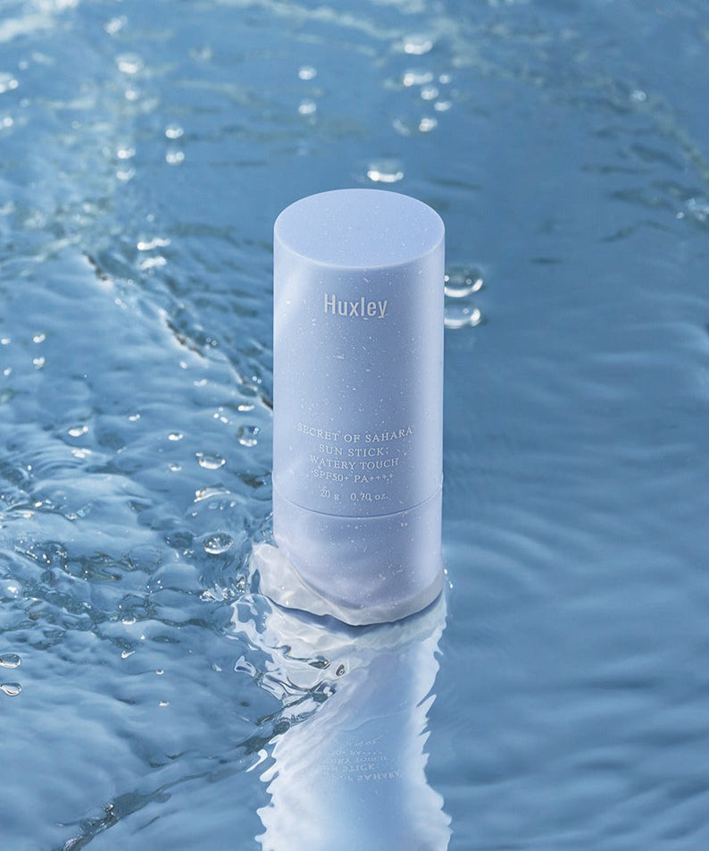 HUXLEY Sun Stick Watery Touch 20g in water, showcasing waterproof sun protection and hydrating benefits in a sleek design.